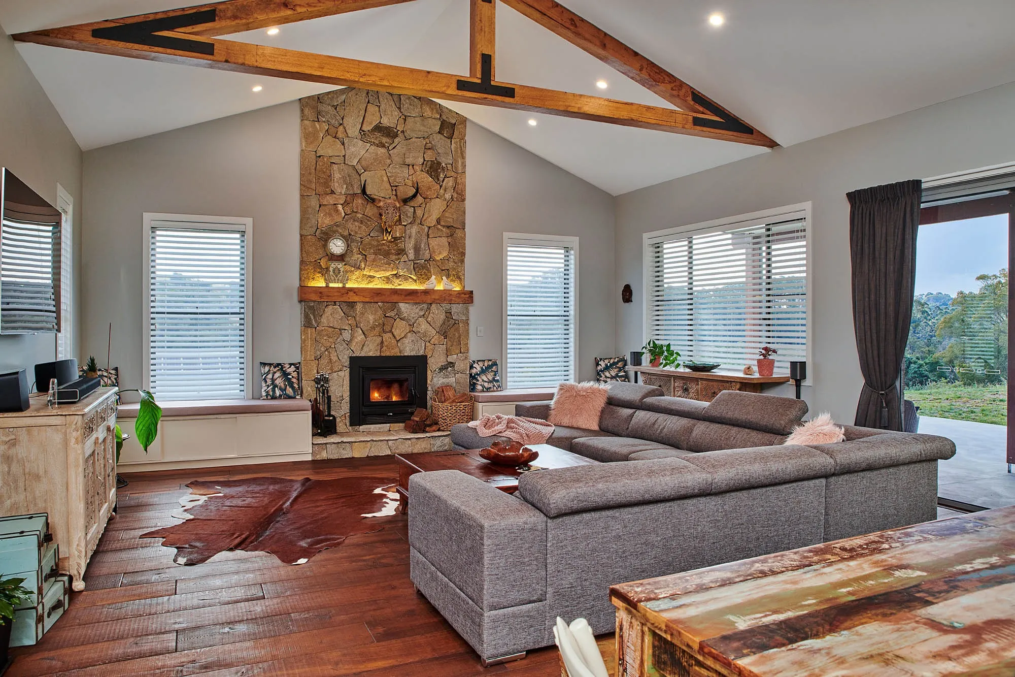 Vaulted living room with venetian blinds on every window